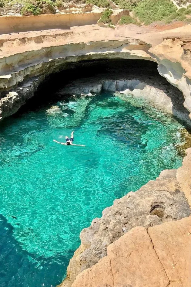 A swimmer floating in the clear water of St Peter’s Pool