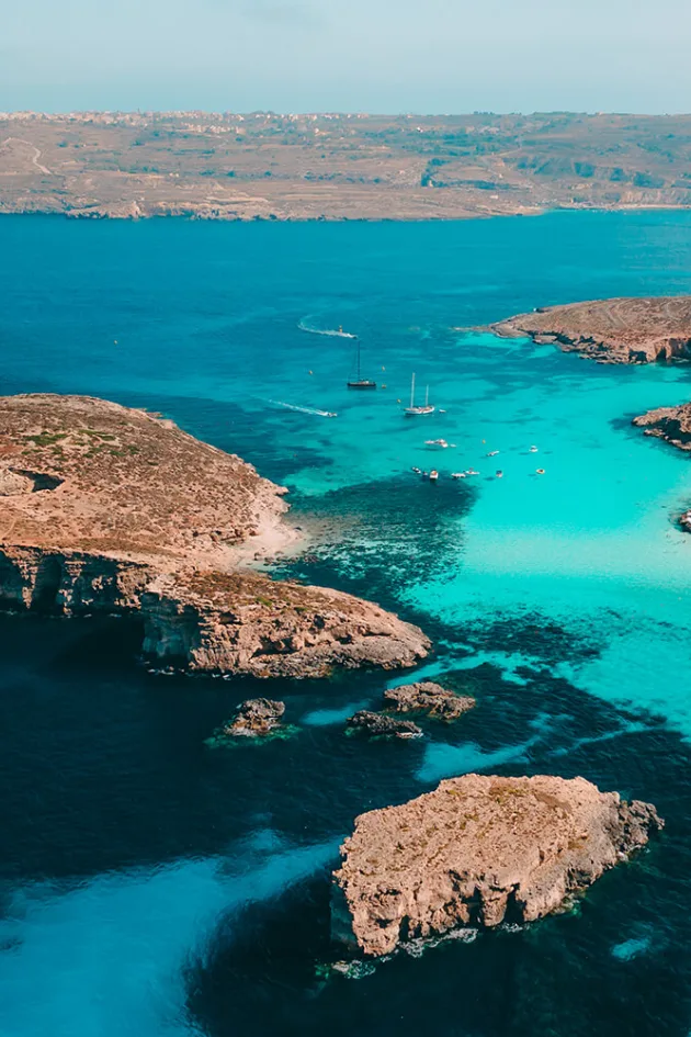Boats anchored on the bright turquoise water of the Blue Lagoon