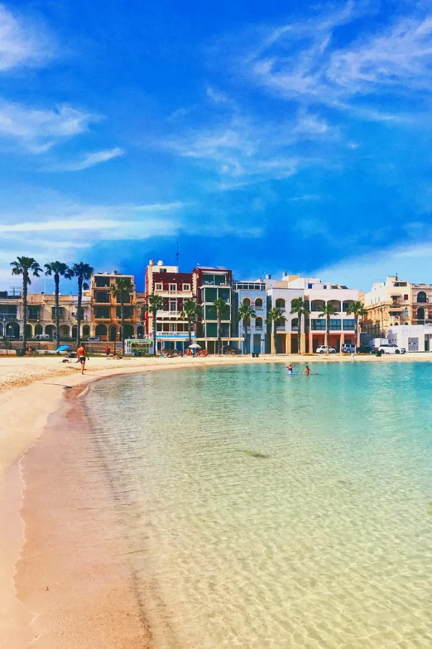 Shallow turquoise water and colourful seafront buildings at Pretty Bay